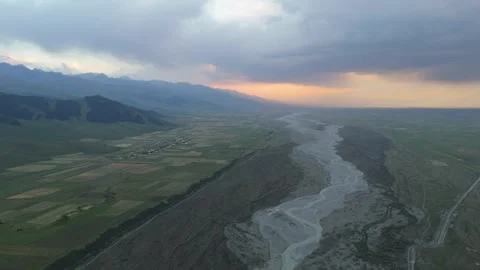 Aerial view of a braided river through farmland at sunset, Kyrgyzstan Stockbeeldmateriaal 347241037
