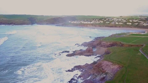 Aerial view of breaking waves and costal village with horseshoe bay in the sun Video stock 114517811