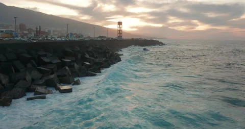 Aerial view. Breaking waves and cubic wave breakers in Puerto de la Cruz city on Stock Footage 147321426