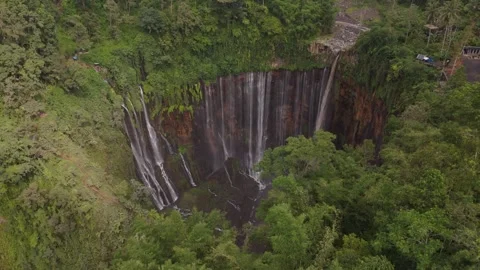 Aerial view of a breathtaking waterfall in the dense, green forests of Java, Video stock 330616136