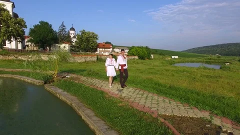 Aerial view of bride and groom walking along a lake on wedding day. Happy Stock Footage