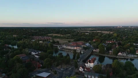 Aerial view of a bridge crossing a river, lined with houses and trees, unde.. Stock Footage 340522934
