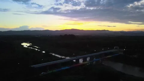 Aerial View of Bridge Over River at Sunset with Mountain Silhouette Video stock 308228911