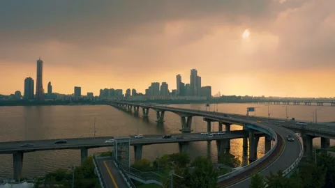 Aerial view of a bridge over a wide river with cityscape and skyscrapers at.. Stockbeeldmateriaal 334774863
