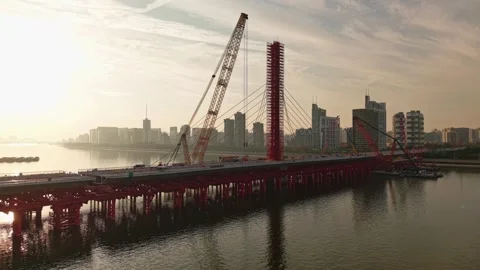 Aerial view of bridge sections being dismantled with a large crane over a river Stock Footage 325717686