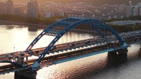 Aerial view of bridge with traffic during sunset in a bustling urban area Stock Footage 309093769