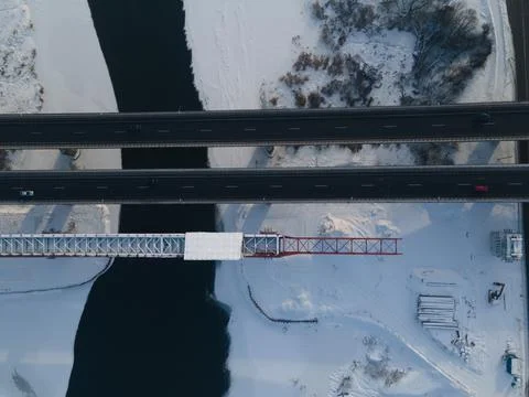 Aerial view of the bridge under construction over the river in winter. 库存照片