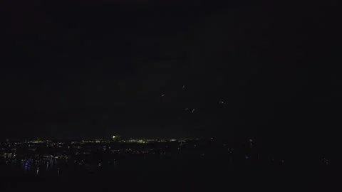 Aerial view of bright fireworks exploding with colorful lights over sea shore on Stock Footage 213374023