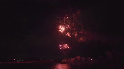 Aerial view of bright fireworks exploding with colorful lights over sea shore on Video stock 219248332