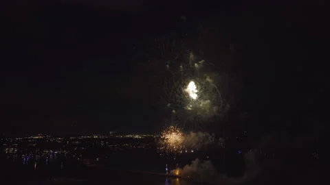 Aerial view of bright fireworks exploding with colorful lights over sea shore on Stock Footage 219629303