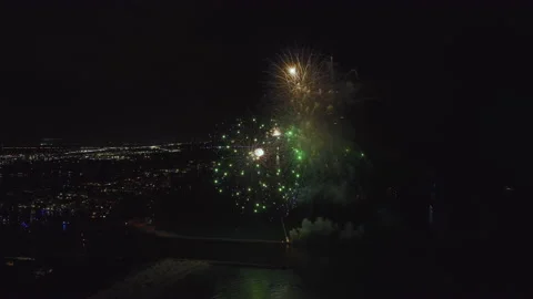 Aerial view of bright fireworks exploding with colorful lights over sea shore on Stock Footage 221429785