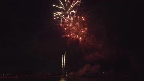 Aerial view of bright fireworks exploding with colorful lights over sea shore on Stock Footage 222694904