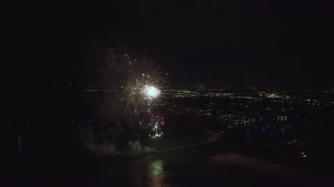 Aerial view of bright fireworks exploding with colorful lights over sea shore on Stock Footage 224183252