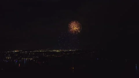 Aerial view of bright fireworks exploding with colorful lights over sea shore on Stock Footage 229914673