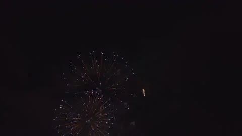 Aerial view of bright fireworks exploding with colorful lights over sea shore on Stock Footage 231768750