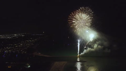 Aerial view of bright fireworks exploding with colorful lights over sea shore on Stock Footage 256255403