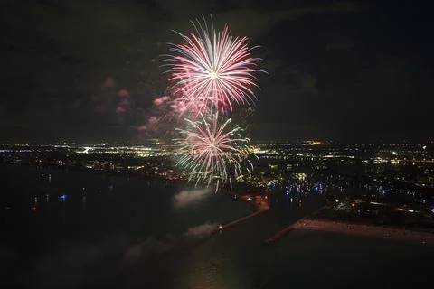 Aerial view of bright fireworks exploding with colorful lights over sea shore on Foto stock