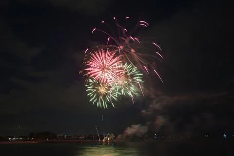 Aerial view of bright fireworks exploding with colorful lights over sea shore on Foto stock