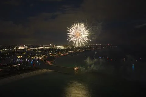 Aerial view of bright fireworks exploding with colorful lights over sea shore on Foto stock