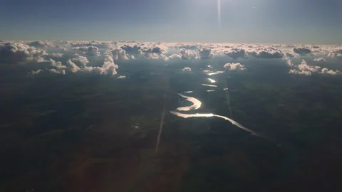 Aerial View, Bright rays of sunlight illuminate clouds, sun glare reflects off Stock Footage 339038653
