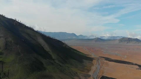 Aerial view of Bromo volcano and rugged terrain, Indonesia. Stock Footage 284824090