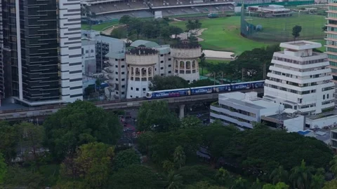 Aerial view of the BTS Skytrain moving on an elevated track through downtown Stock Footage 327208629