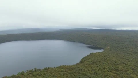 Aerial view of Buey Lagoon surrounded by lush greenery Video stock 330760071