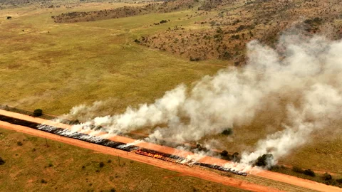 Aerial view of a buffer boundary burning for fire prevention and conservation Stock Footage 307891124