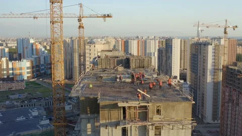 Aerial view builders in helmets and vests build a high-rise house of concrete Video stock 132049517