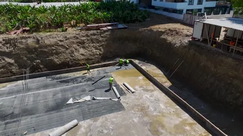 Aerial View: Builders insulate foundations and secure metalwork while engineers Stock Footage 296094906
