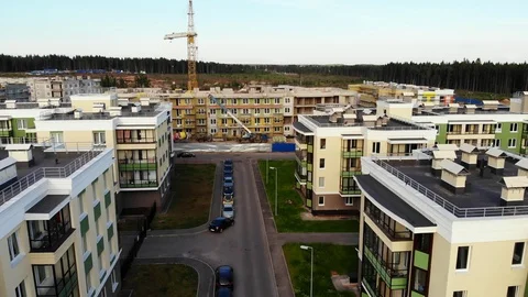 Aerial view on buildings under construction, crane with cargo Stock Footage 92444277