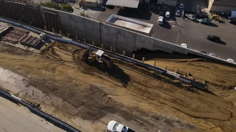 Aerial view of bulldozer at work during construction on California freeway. Stock Footage 164084399
