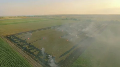 Aerial view of a burning field, outside a city, the air is filled with smoke Stock Footage 78043822