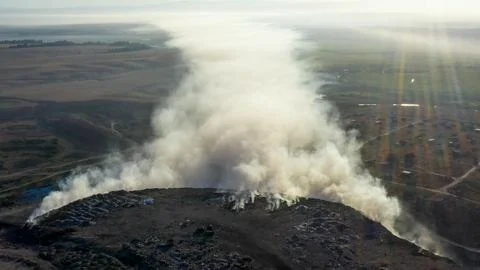 Aerial view of burning garbage piles in trash landfill Stock Photos