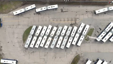 Aerial view of a bus fleet parked in a lot, showcasing a continuous arrangement 库存影片 335876619