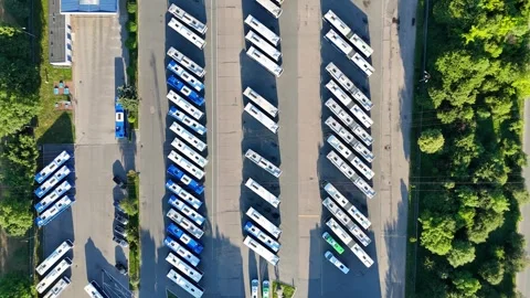 Aerial view of a bus fleet parked in a lot, continuous arrangement of buses Stock-Footage 338174695
