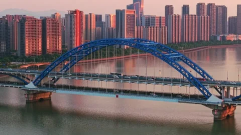 Aerial view of a bustling bridge with traffic and a vibrant city skyline during Stock Footage 311559902