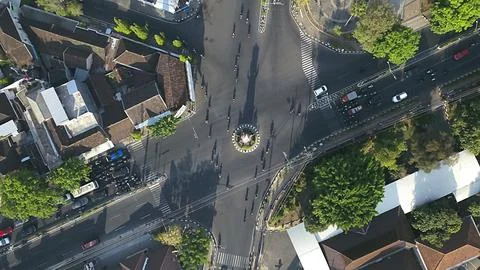 Aerial View of a Bustling City Intersection with Traffic and Greenery Фото