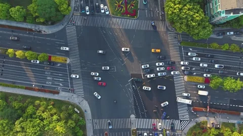 Aerial view of a bustling urban intersection filled with cars and pedestrians. Vídeo Stock 308514304