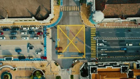 Aerial view of a busy city intersection with traffic lanes, vehicles, crosswalks Stock Footage 295764043