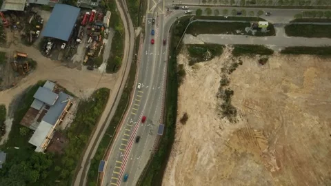 Aerial View of a Busy Highway Intersection Surrounded by Construction and Green Stock Footage 316449619