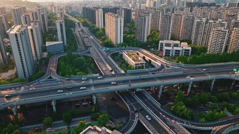 Aerial view of a busy highway junction in an urban setting during early morning Stock Footage 309792452