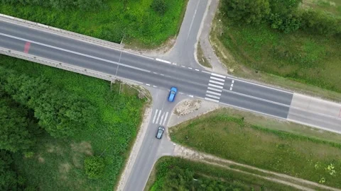 Aerial View of Busy Intersection With Multiple Vehicles in Green Surroundings Stock Footage 280887298