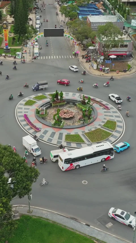 Aerial view of a busy roundabout in Da Lat, Vietnam with many motorbikes and Stock Footage 334632605