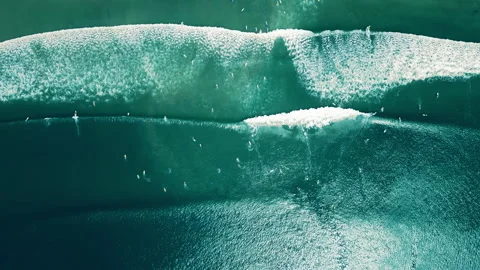 Aerial view busy surf spot, surfers paddle on boards, catch waves, drone footage Stock Footage 261380452