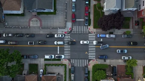 Aerial view of a busy urban intersection with moving vehicles, featuring road Stock Footage 311936051