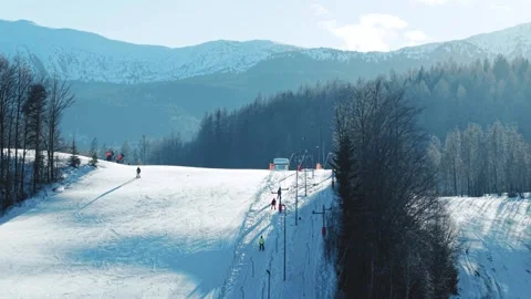 Aerial View of Button Ski-Lift, Skiers and Snow-Covered Mountain View Stock Footage 328846558