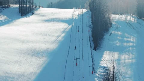 Aerial View of Button Ski-Lift and Skiers on Sunny Winter Day Stock Footage 328846621