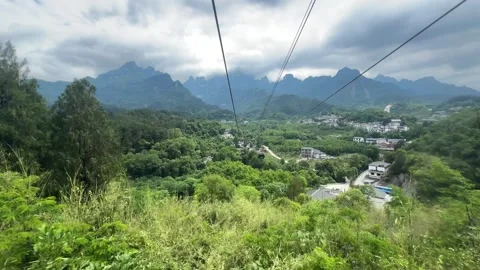Aerial view of cable car riding over green mountain landscape time lapse Stock Footage 337650262