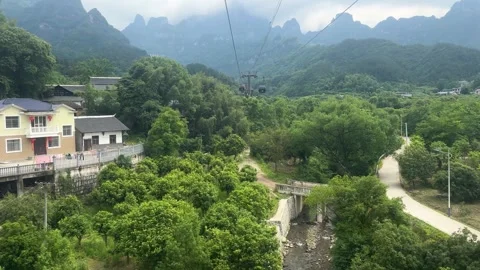 Aerial view of cable car riding over green mountain landscape Video stock 337650438